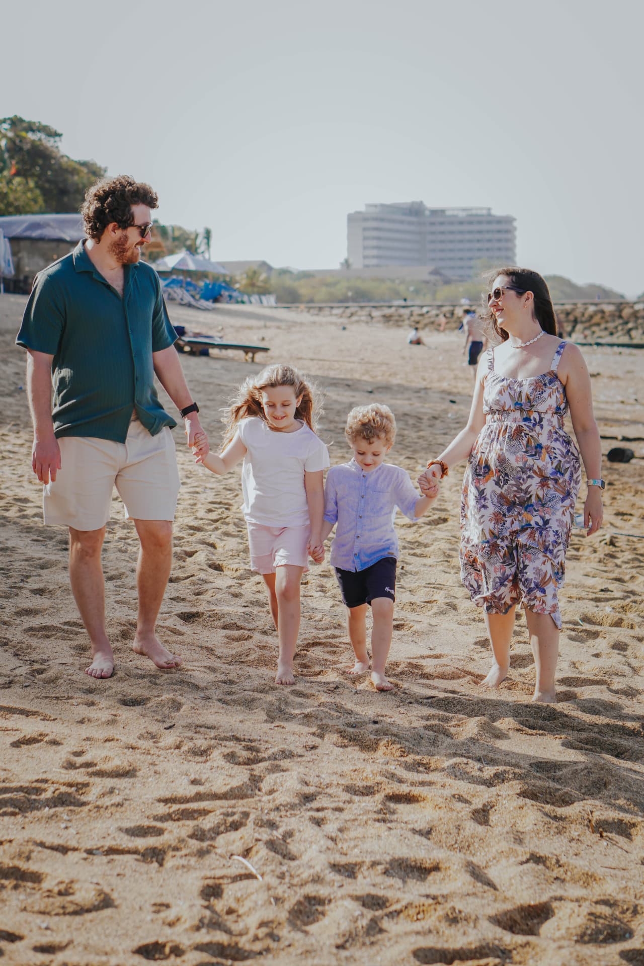 Bali family beach photography — family walking together on a sandy beach in Bali
