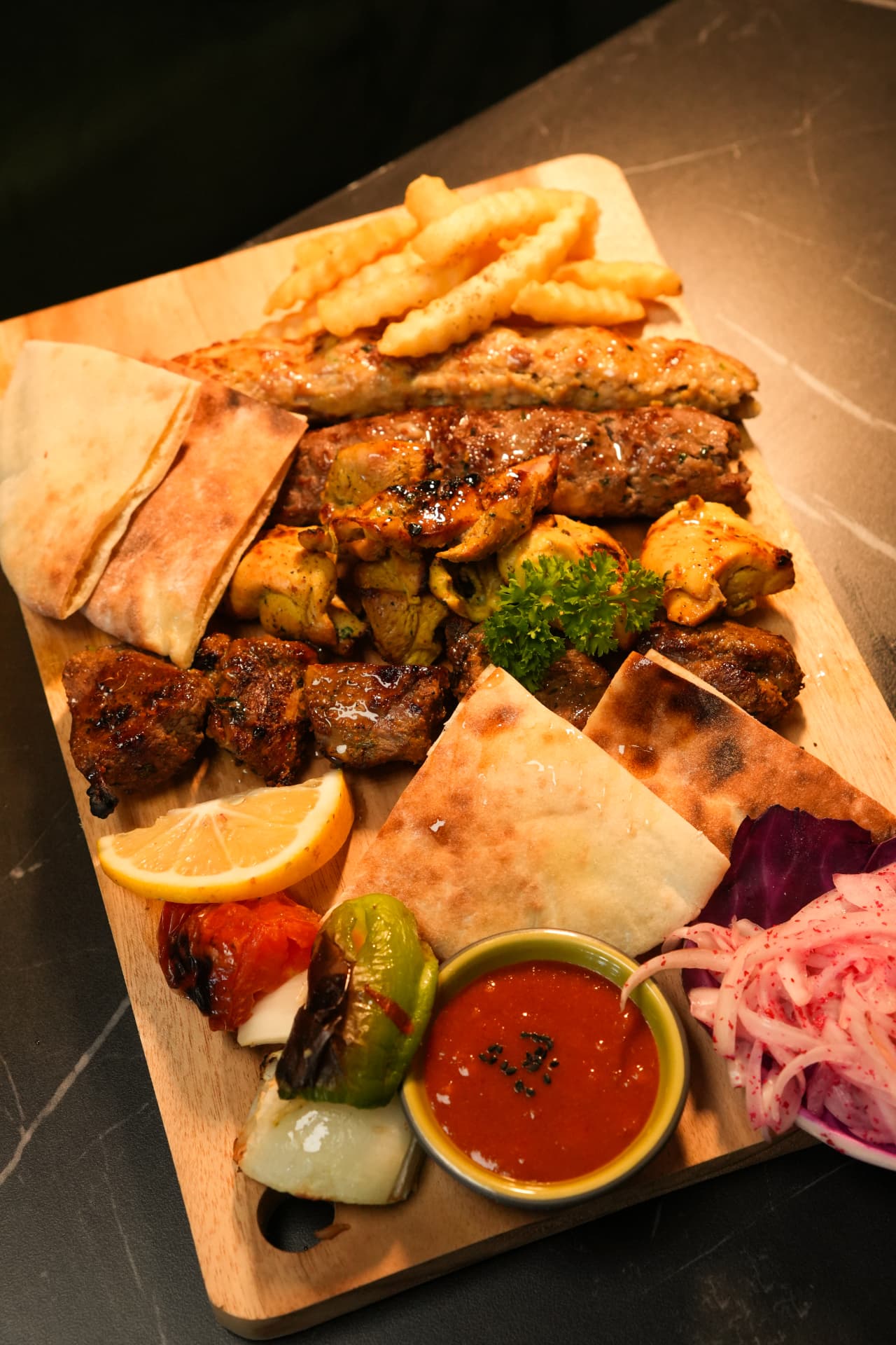 Mixed grill platter with kebabs, pita and sauces shot for a Bali restaurant menu