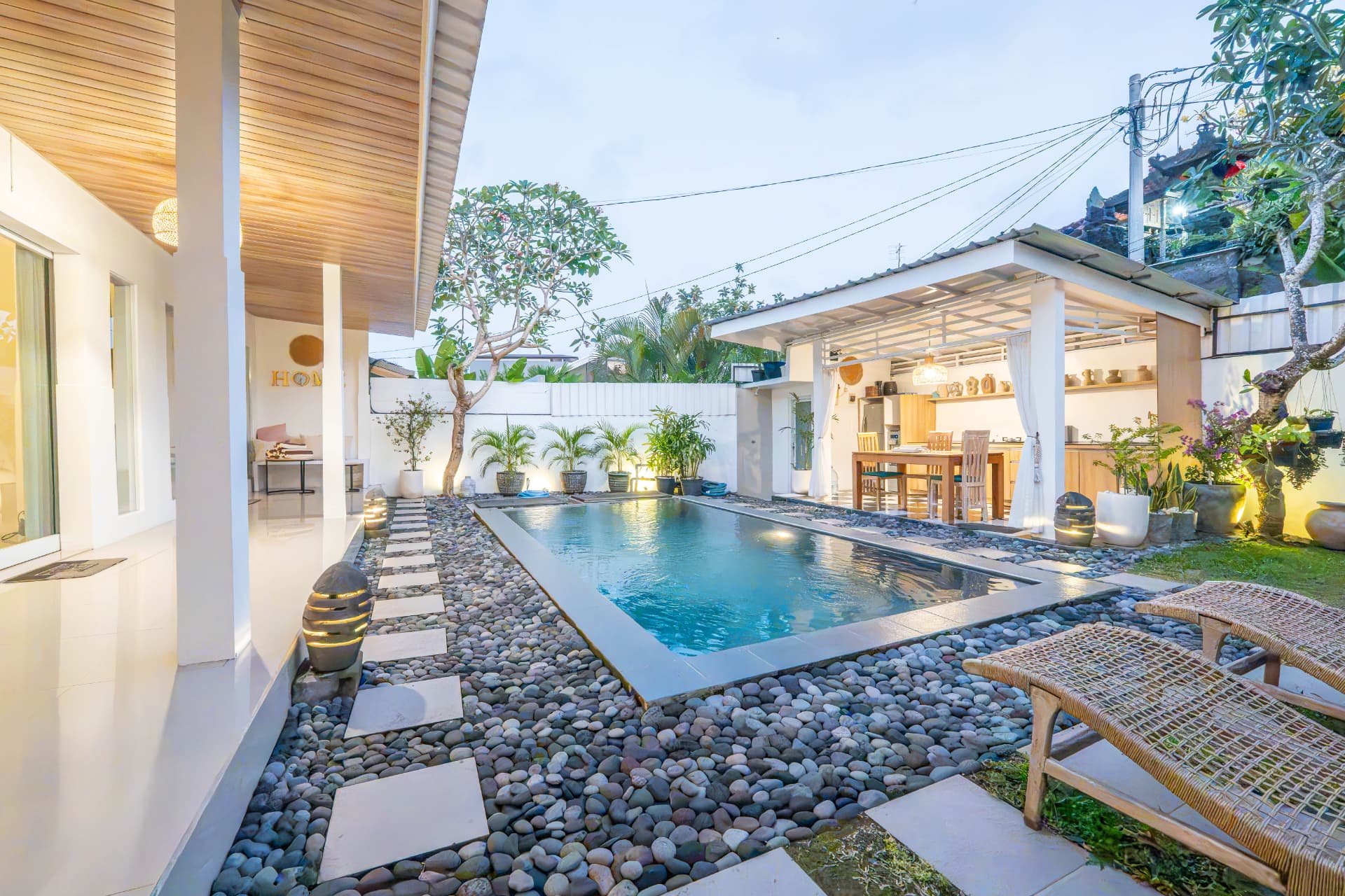 Bali villa poolside and outdoor dining area photographed at twilight for rental listing