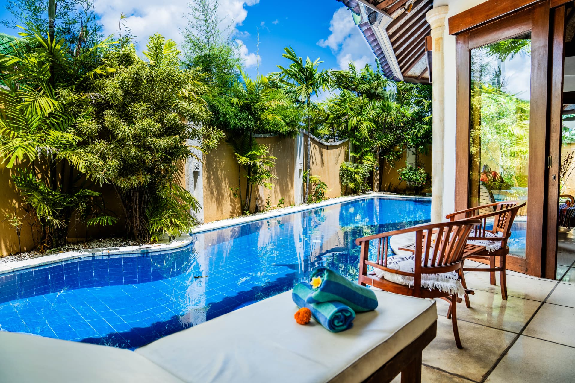Tropical villa pool and sun lounger photographed in daylight in Bali
