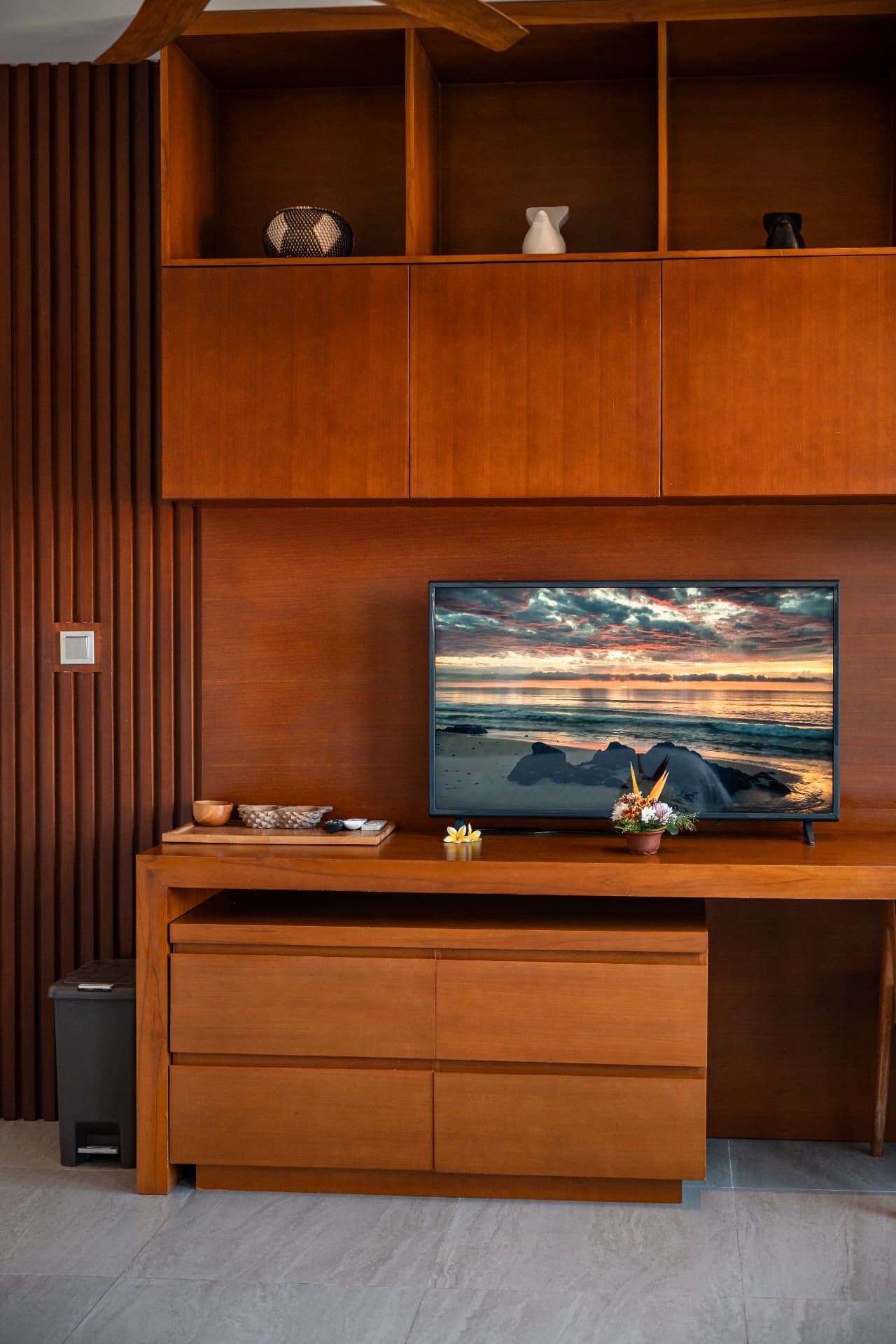 Warm wooden villa interior with built-in shelving and TV for Bali real estate photography