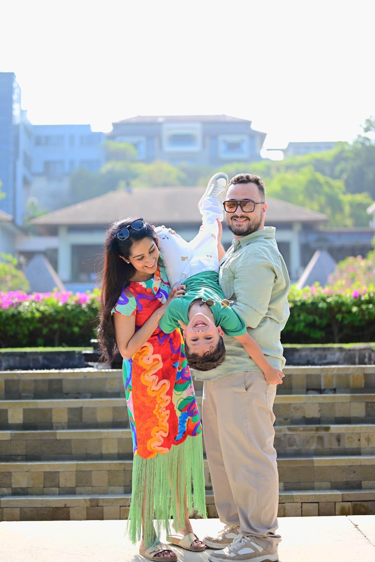 Bali family holiday photography — parents playing with child at a resort in Bali