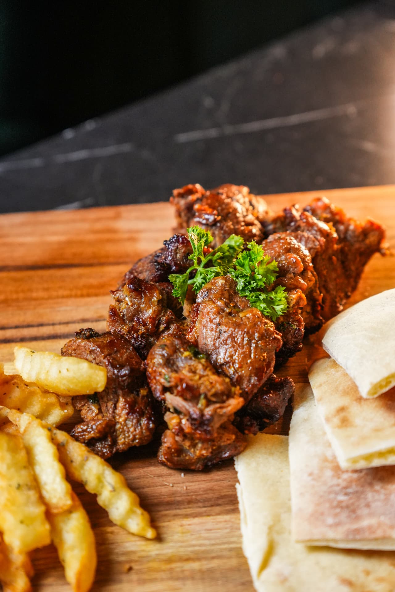 Grilled beef skewers with fries and flatbread photographed close up in Bali